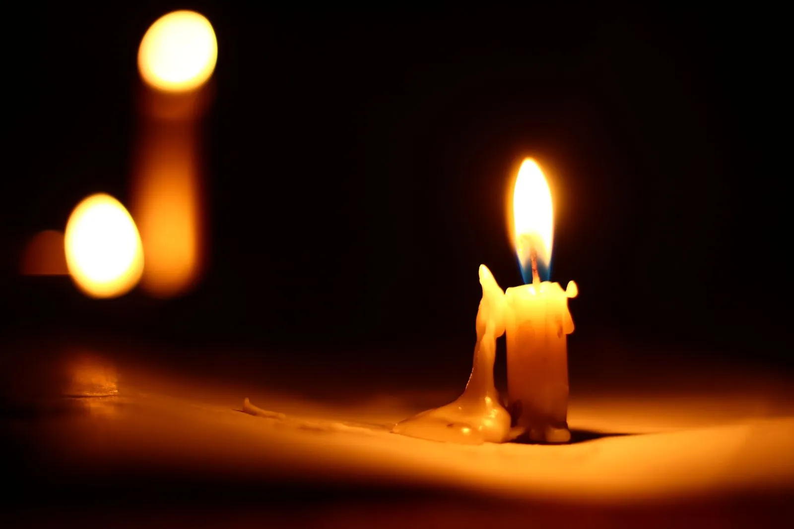 A single candle burning in a dark room